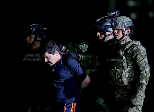Recaptured drug lord Joaquin "El Chapo" Guzman is escorted by soldiers in Mexico City