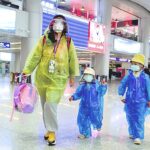 Passengers wearing face masks and raincoats walk through a nearly empty departure hall at Beijing Capital International Airport as the country is hit by an outbreak of the novel coronavirus